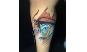 Tatuajes ojo con colibríes y arcoíris vibrantes. Un ojo realista con detalles de fantasía, como si los colibríes volaran a través de un portal de colores.
