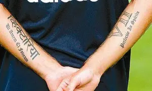 Brazos de Haidar Juma con tatuajes: "Victoria" en sánscrito y "Perfectio In Spiritu" en latín.