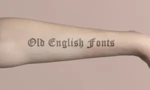 Brazo con tatuajes de letras góticas, "Old English Fonts", que parecen obras de arte permanentes.