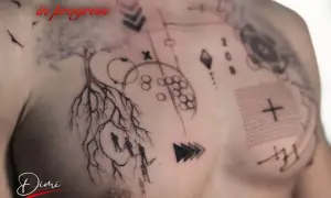 Tatuaje en progreso en el pecho: árbol con raíces, figuras humanas y elementos geométricos. El artista muestra cómo quitar el film del tatuaje.