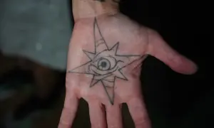 Tatuajes de protección contra el mal y su significado: un ojo dentro de una estrella de ocho puntas en la palma de la mano, símbolo de vigilancia y escudo.