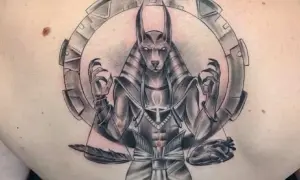 Tatuaje de Anubis con un corazón y pluma, simbolizando el juicio y el significado de la vida.