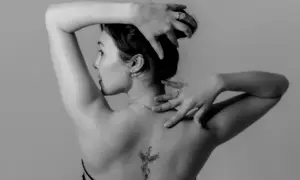 Mujer con un tatuaje de fénix en la espalda, símbolo de renacimiento y fuerza.