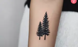 Tatuaje de dos pinos negros en un brazo, simbolizando la fuerza y el crecimiento del bosque.