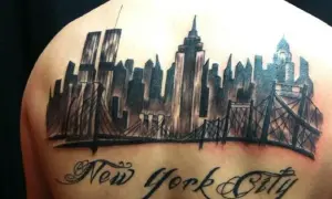 Tatuaje de un horizonte de Nueva York con puentes y el texto "New York City" en caligrafía.