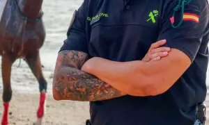 Agente de la Guardia Civil con tatuajes florales en el brazo, mostrando que los tatuajes en el trabajo son cada vez más aceptados.