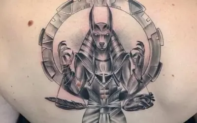 Tatuaje de Anubis con un corazón y pluma, simbolizando el juicio y el significado de la vida.