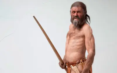 Recreación de Ötzi, el hombre del hielo, mostrando sus antiguos tatuajes y su bastón.