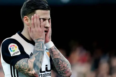 Yeray Pérez, futbolista con tatuajes, se lleva las manos a la cara con gesto de frustración.