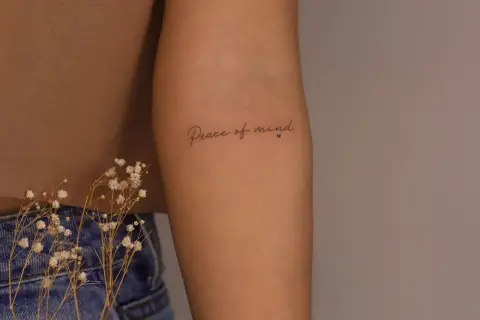Brazo con tatuaje de "Peace of mind", un recordatorio constante de la paz interior.