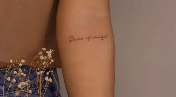 Brazo con tatuaje de "Peace of mind", un recordatorio constante de la paz interior.
