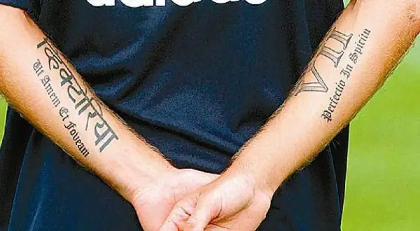 Brazos de Haidar Juma con tatuajes: "Victoria" en sánscrito y "Perfectio In Spiritu" en latín.