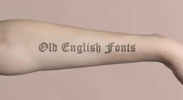 Brazo con tatuajes de letras góticas, "Old English Fonts", que parecen obras de arte permanentes.