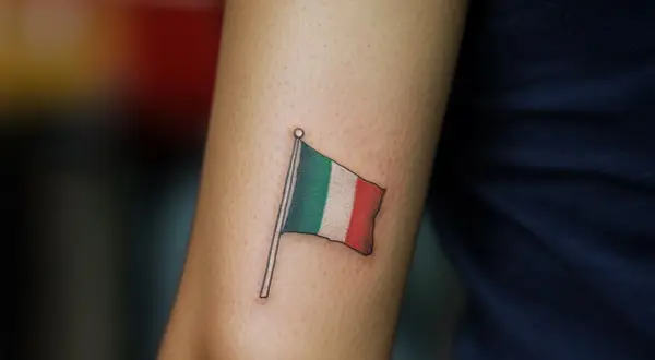 Un tatuaje de la bandera de Italia ondea en un brazo, un recordatorio permanente de la belleza y la cultura de ese país.