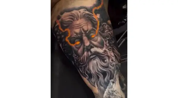 Impresionante diseño de tattoo de Zeus con ojos llameantes y rayos.