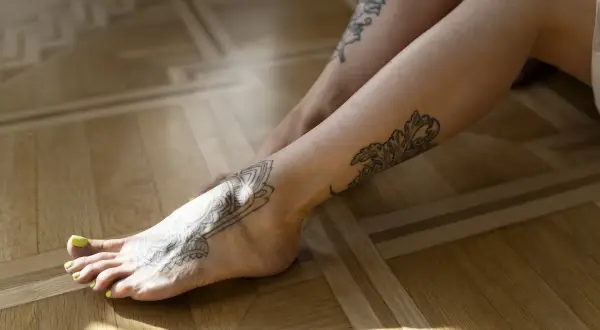 Piernas con tatuajes de mandalas y hojas. Quizás aquí es donde duele mas un tatuaje, en el pie.