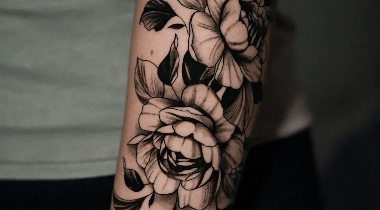 Un tatuaje de peonías en blanco y negro en un brazo. Una inspiración para saber como elegir un tatuaje que te represente.