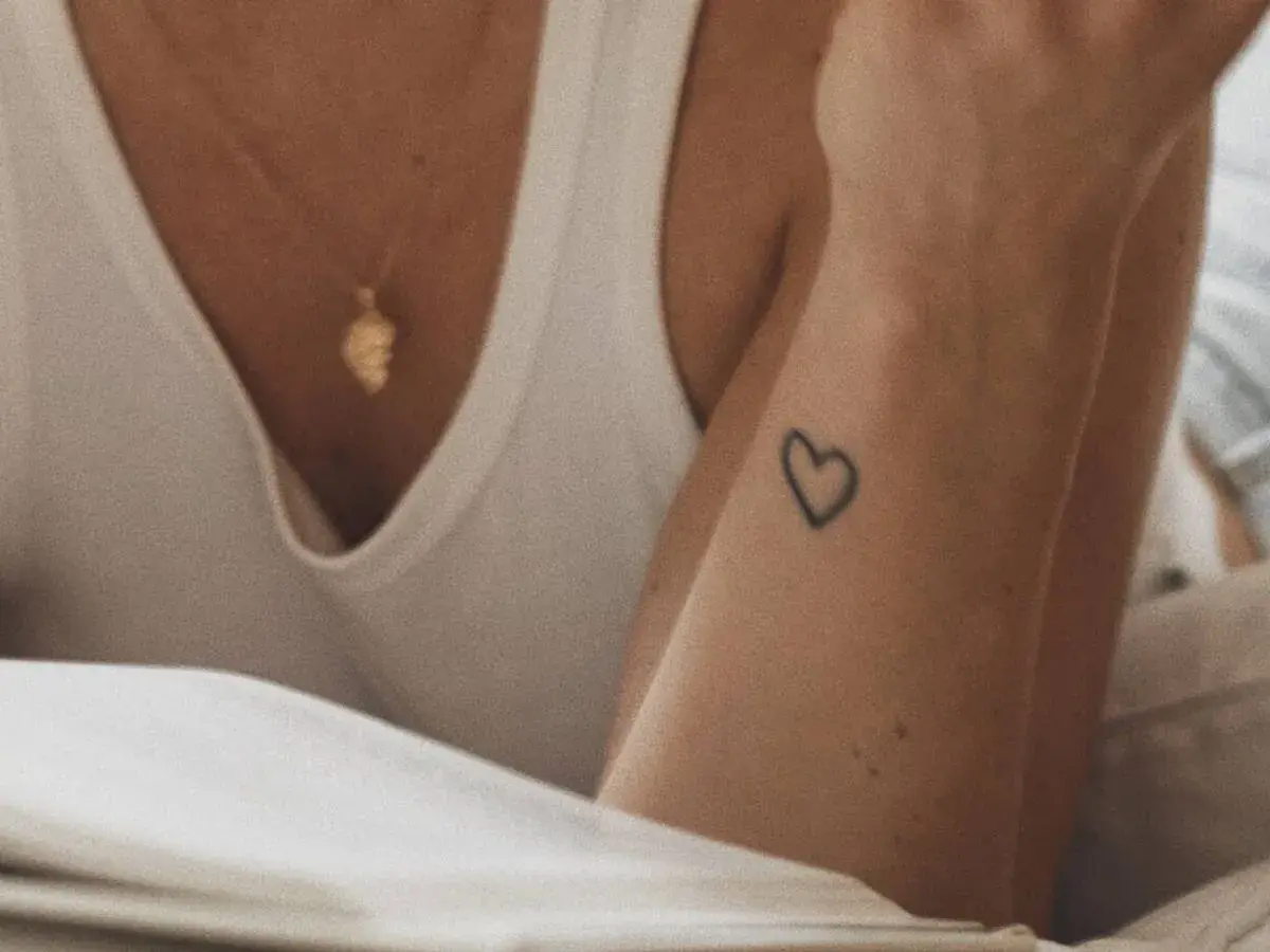 Un corazón tatuado en la muñeca, un detalle sutil para quienes buscan los mejores sitios para hacerse un tatuaje.