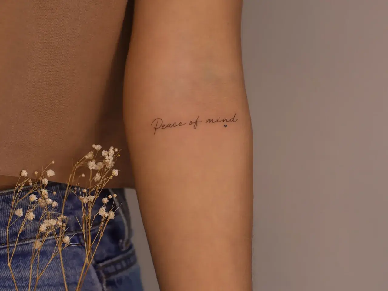 Brazo con tatuaje de "Peace of mind", un recordatorio constante de la paz interior.