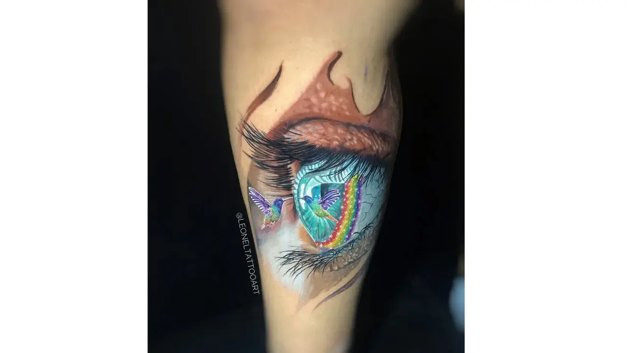 Tatuajes ojo con colibríes y arcoíris vibrantes. Un ojo realista con detalles de fantasía, como si los colibríes volaran a través de un portal de colores.