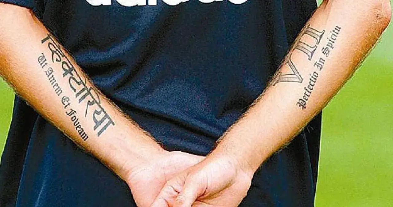 Brazos de Haidar Juma con tatuajes: "Victoria" en sánscrito y "Perfectio In Spiritu" en latín.