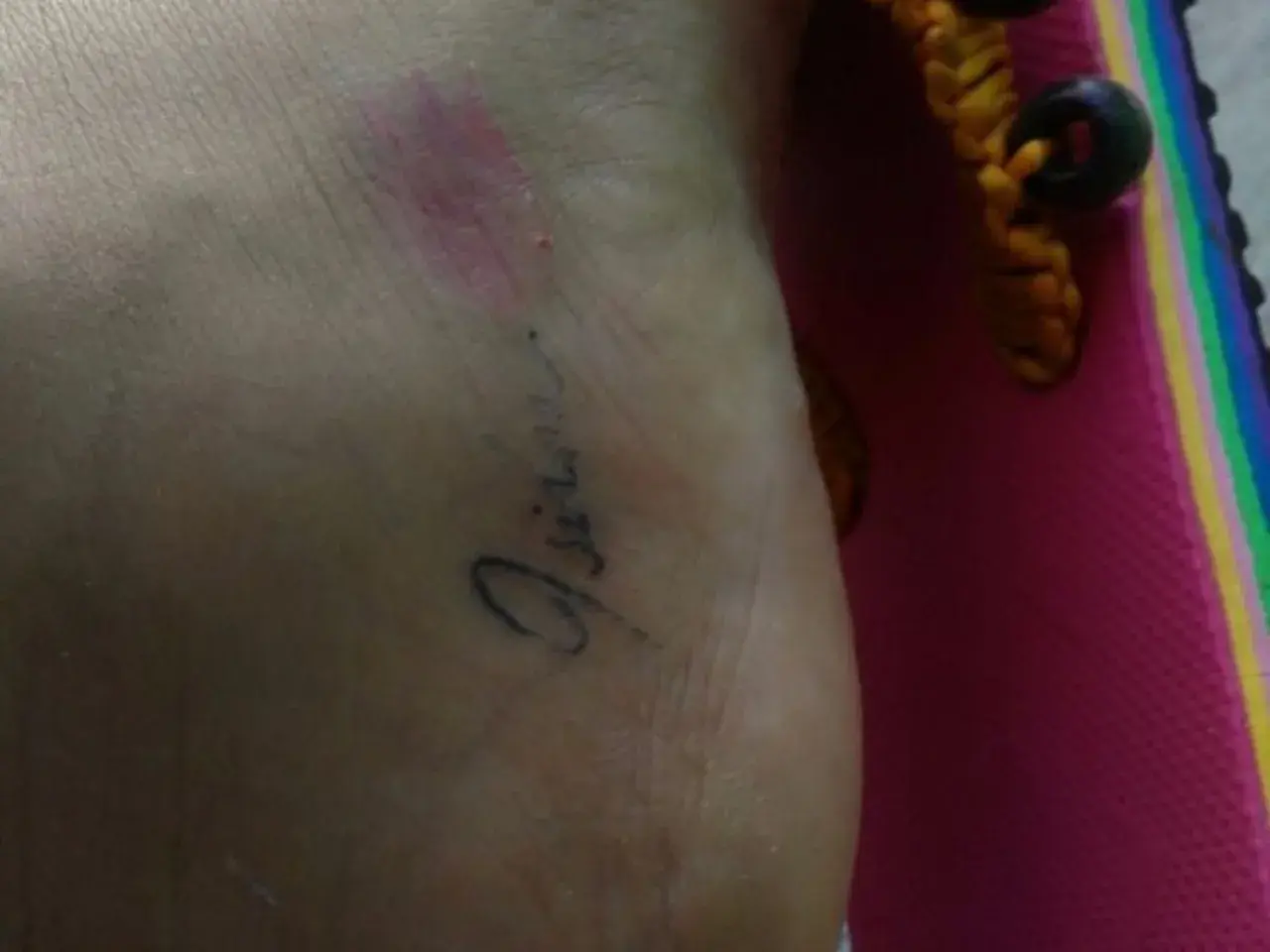 Mi tatuaje se pela y pierde color, mostrando la piel debajo. Se ve un brazalete con cuentas.