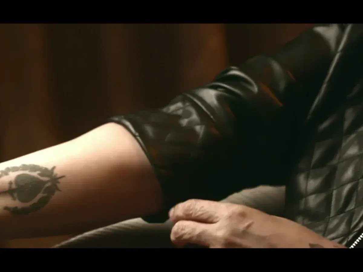 Tatuaje de una mujer con un diseño de espada en el brazo.
