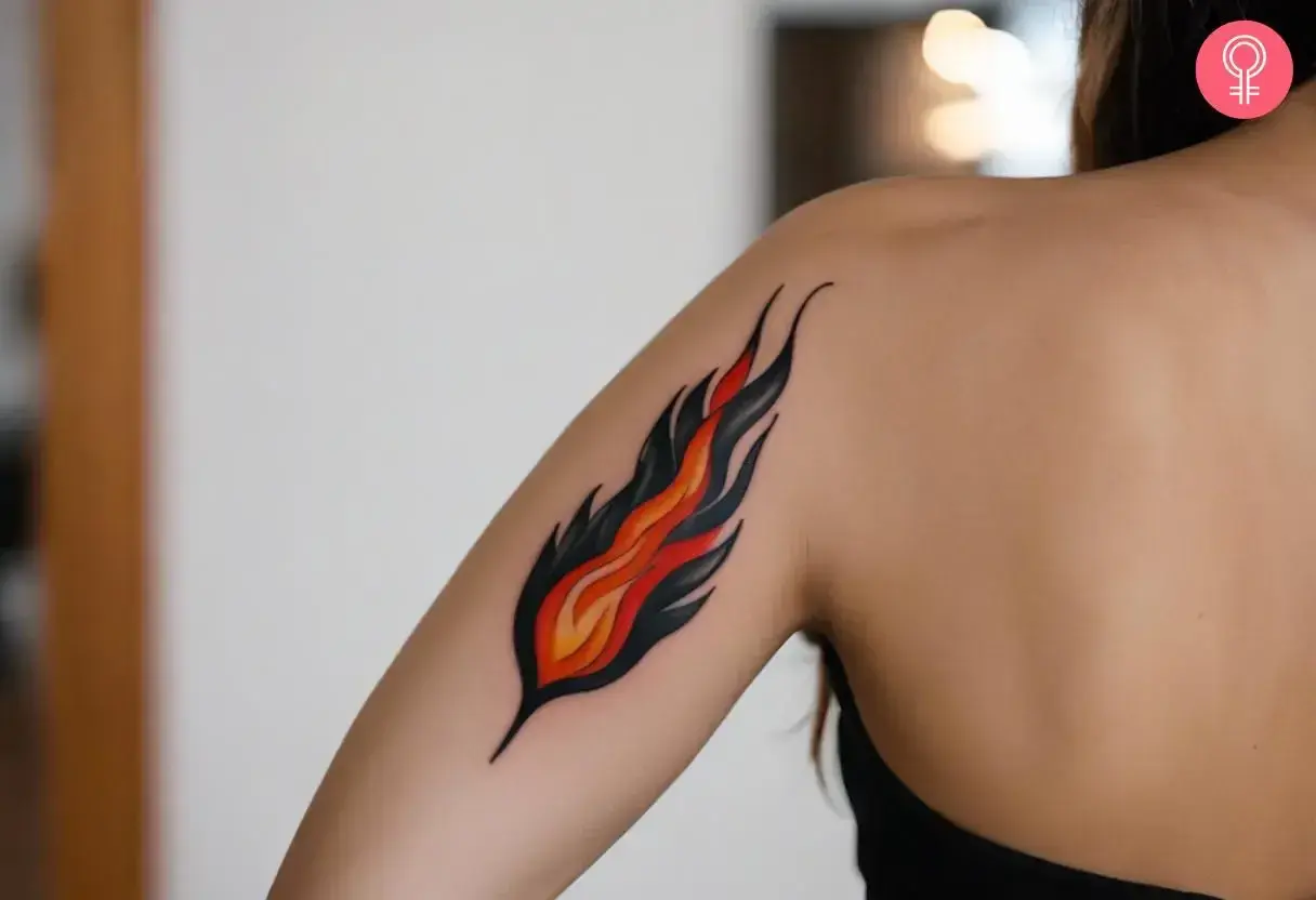 Tatuaje de fuego estilizado en el brazo de una persona.