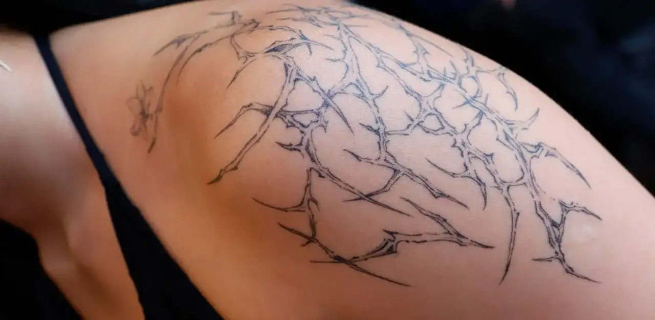 Tatuaje de espinas y una flor, explorando el significado de símbolos en tatuajes.