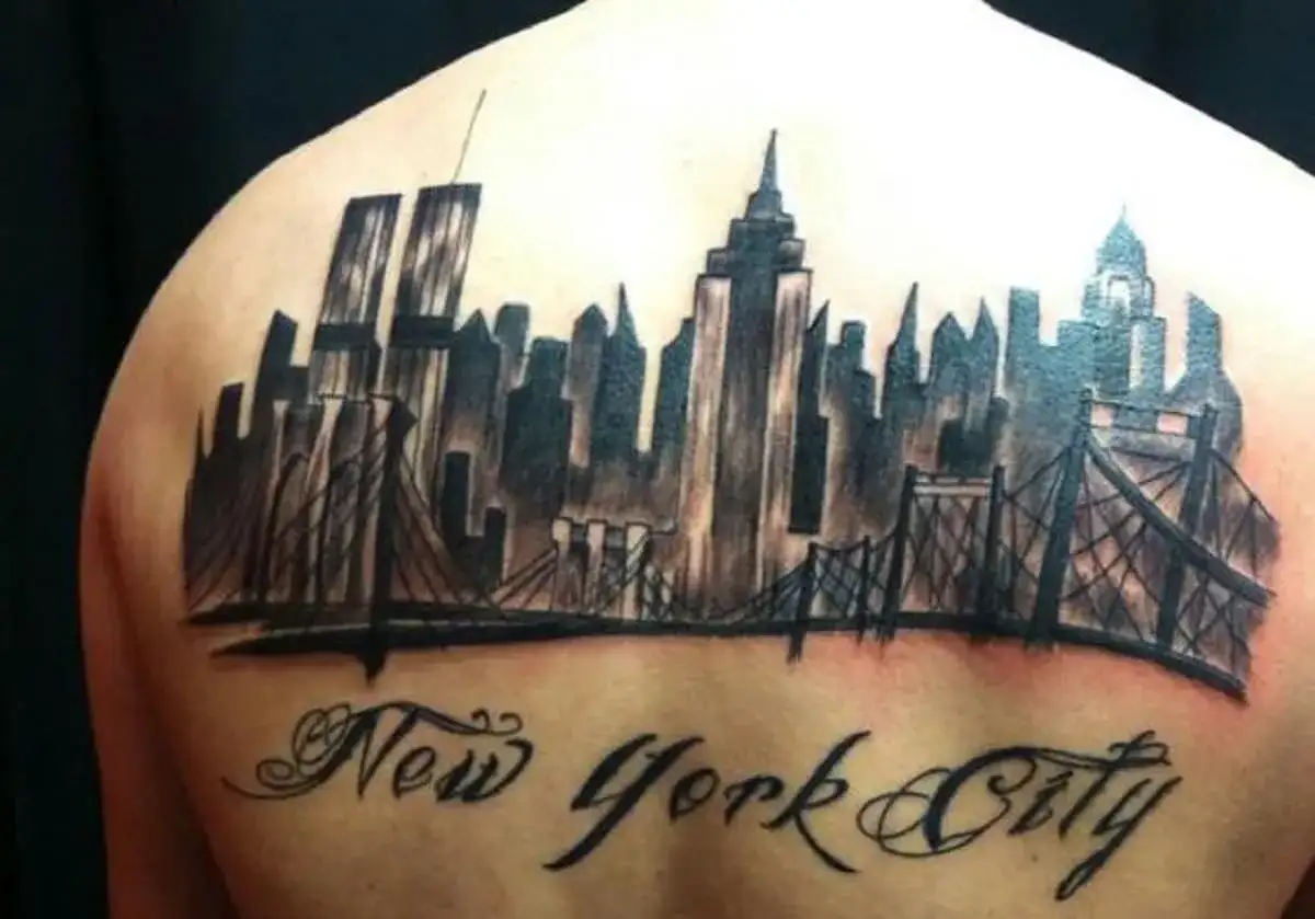 Tatuaje de un horizonte de Nueva York con puentes y el texto "New York City" en caligrafía.