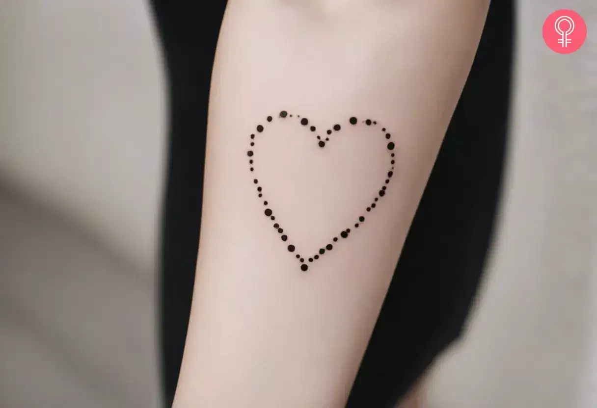 Un delicado tatuaje de corazón formado por puntos, un símbolo de amor eterno.