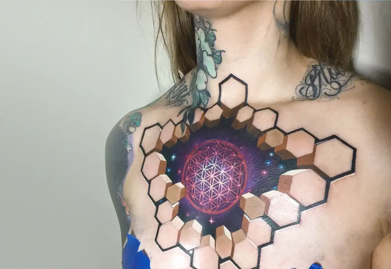 Un impresionante tatuaje 3D en el pecho, con un dise&ntilde;o geom&eacute;trico que se abre a un cosmos estrellado.
