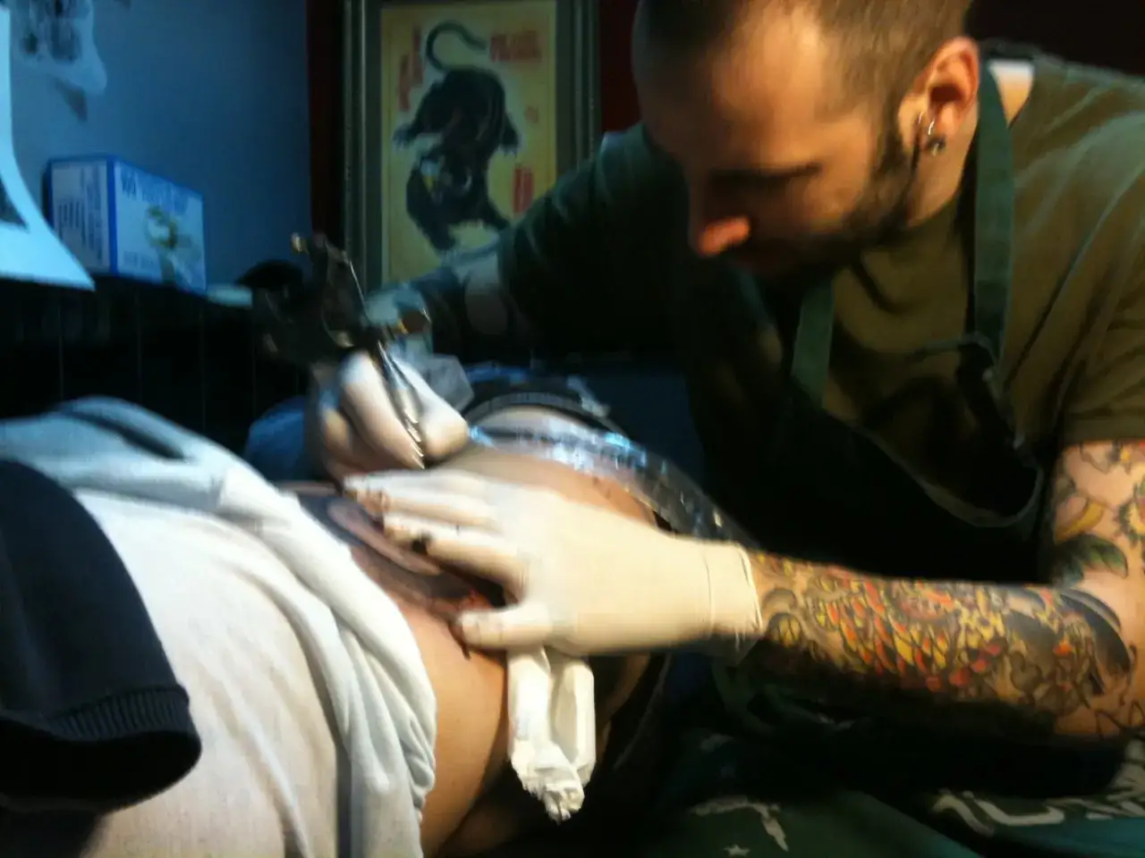 Haidar Juma, un artista del tatuaje, trabaja en un diseño detallado en la piel de un cliente.