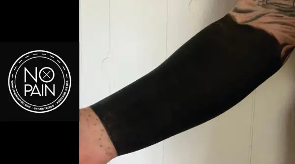 Brazo cubierto con un tatuaje de blackout, un estilo que transforma la piel en una superficie negra intensa.