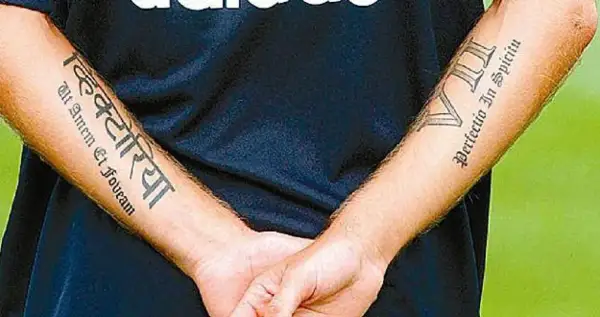 Brazos de Haidar Juma con tatuajes: "Victoria" en sánscrito y "Perfectio In Spiritu" en latín.