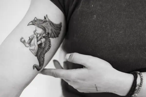 Un tatuaje de un niño con un casco de dinosaurio, con detalles intrincados, que evoca la magia de los tatuajes sevillanos.