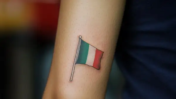 Un tatuaje de la bandera de Italia ondea en un brazo, un recordatorio permanente de la belleza y la cultura de ese país.