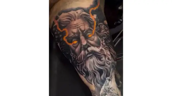 Impresionante diseño de tattoo de Zeus con ojos llameantes y rayos.