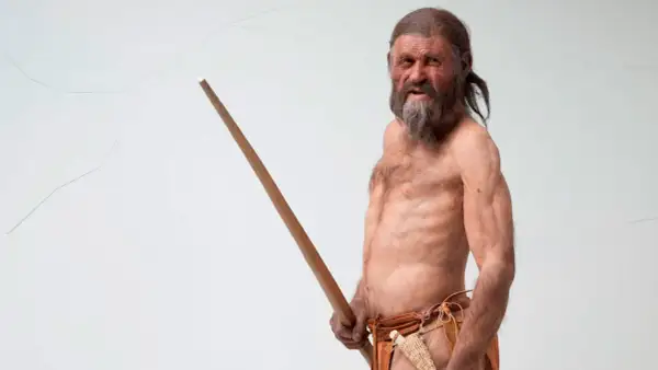 Recreación de Ötzi, el hombre del hielo, mostrando sus antiguos tatuajes y su bastón.